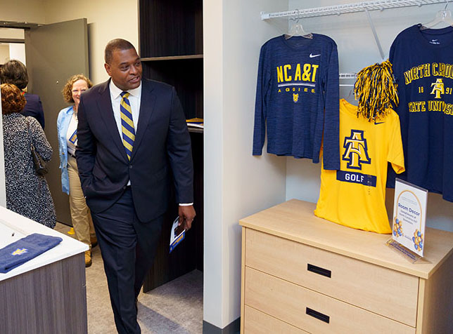 BOT member and alumnus Michael S. Regan walks into a Bluford Residence Hall dorm room decorated with Aggie apparel
